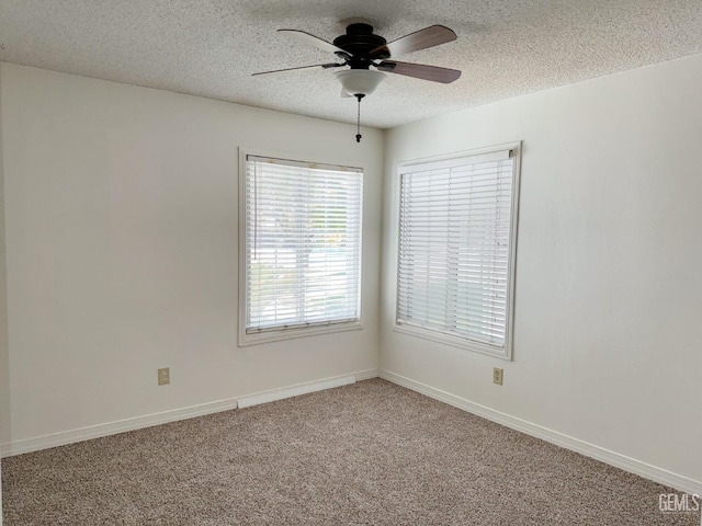 carpeted empty room featuring a textured ceiling, ceiling fan, and baseboards