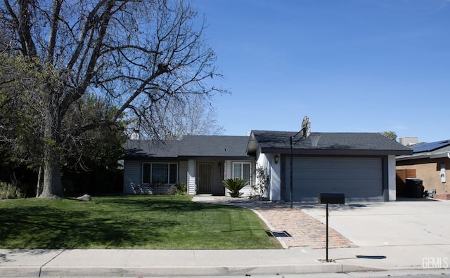 ranch-style home featuring a garage, driveway, and a front yard