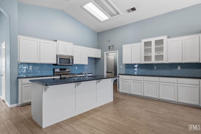 10415 Olympia Fields Dr, Bakersfield, CA 93312 - kitchen with appliances with stainless steel finishes, high vaulted ceiling, a sink, decorative backsplash, and a breakfast bar area