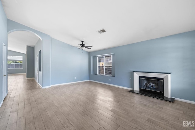 10415 Olympia Fields Dr, Bakersfield, CA 93312 - unfurnished living room with a ceiling fan, wood finished floors, a glass covered fireplace, lofted ceiling, and baseboards