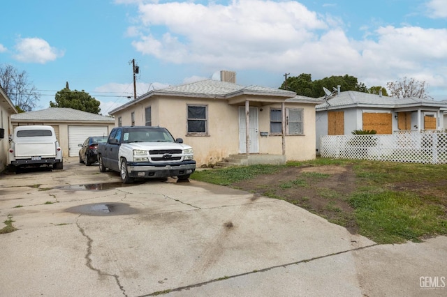 view of front of home with an outbuilding, a garage, and stucco siding