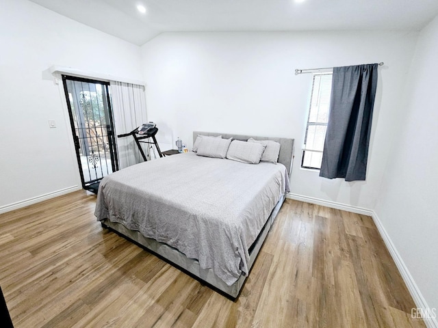 bedroom with vaulted ceiling, access to outside, and light wood-type flooring