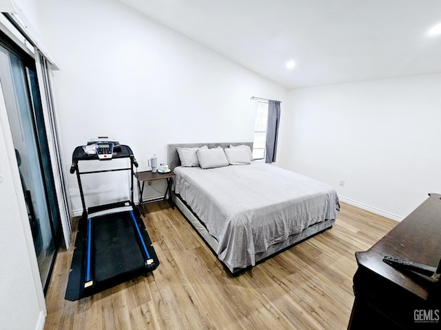 bedroom with lofted ceiling and light hardwood / wood-style floors