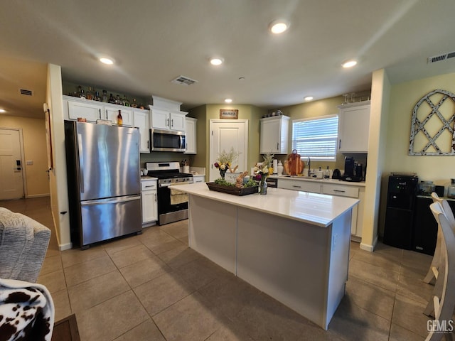 5911 Bogart Dr, Bakersfield, CA 93313 - kitchen with stainless steel appliances, light countertops, white cabinets, light tile patterned flooring, and recessed lighting