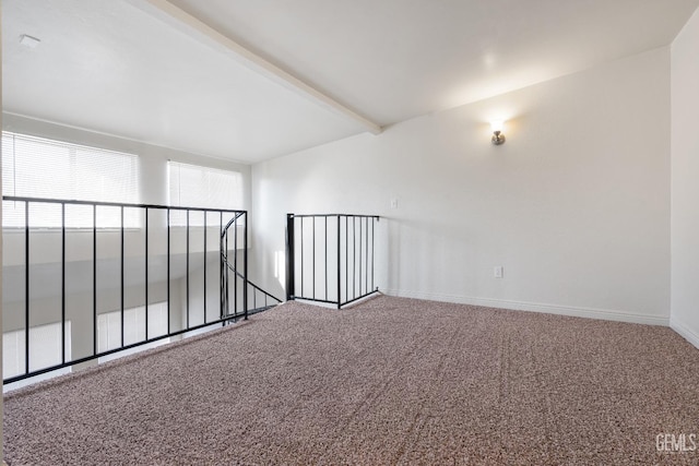 empty room with beam ceiling and carpet floors