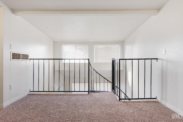 interior space featuring carpet and vaulted ceiling with beams