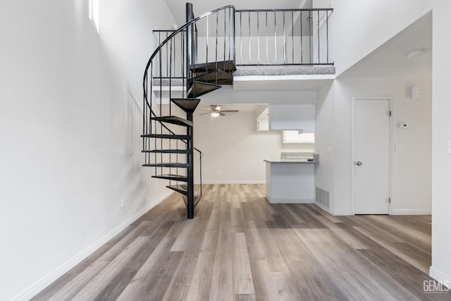 stairs featuring hardwood / wood-style flooring and a towering ceiling