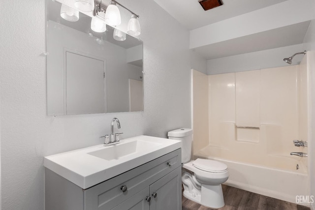 full bathroom featuring wood-type flooring, bathing tub / shower combination, vanity, and toilet