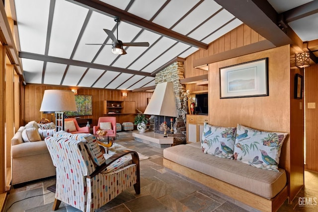 living room featuring lofted ceiling with beams, wood walls, and stone finish flooring