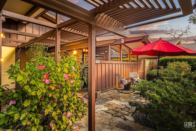 patio terrace at dusk with fence and a pergola