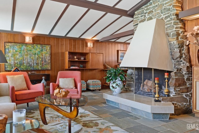 living room with vaulted ceiling with beams, wooden walls, a multi sided fireplace, and stone tile floors