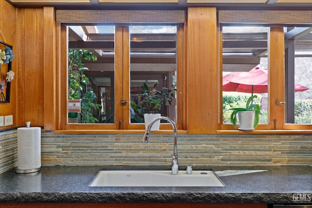 kitchen featuring dark countertops, a sink, and decorative backsplash