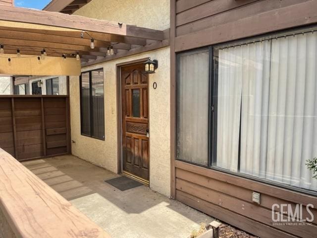 doorway to property featuring stucco siding