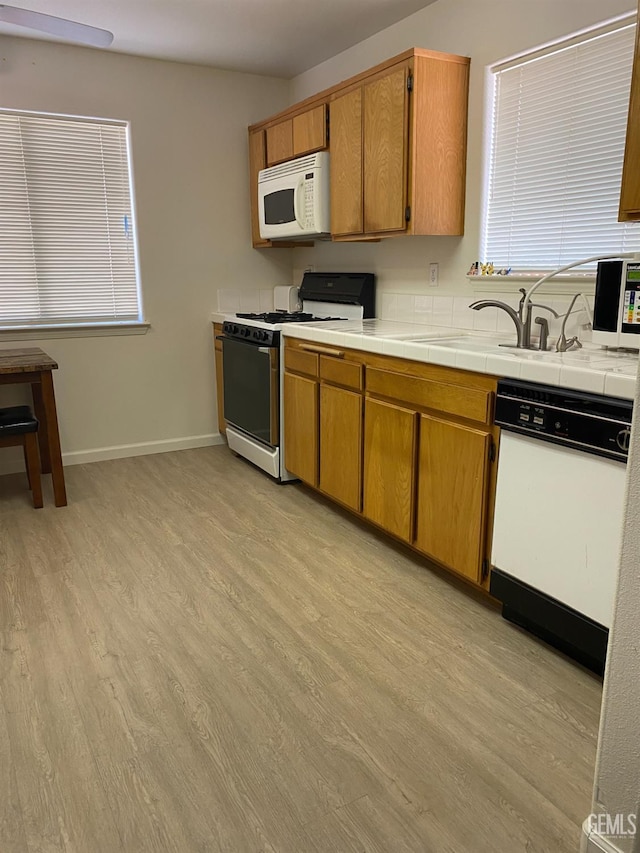 6208 Stonegate Dr, Bakersfield, CA 93306 - kitchen with white appliances, light wood-style floors, and brown cabinetry