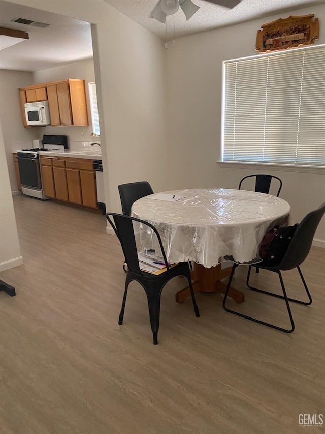 6208 Stonegate Dr, Bakersfield, CA 93306 - dining space with light wood-style flooring and ceiling fan