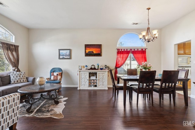 dining space with a chandelier, dark wood-type flooring, visible vents, and baseboards