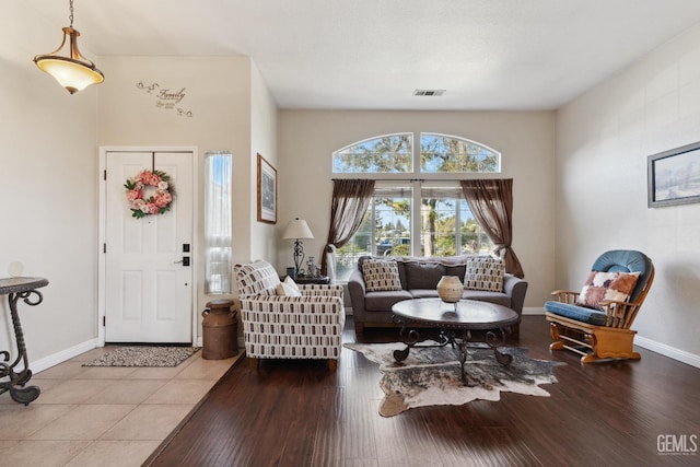 living area featuring visible vents, baseboards, and wood finished floors