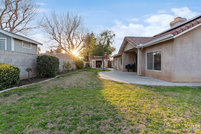 view of yard with a patio, an outdoor structure, and fence