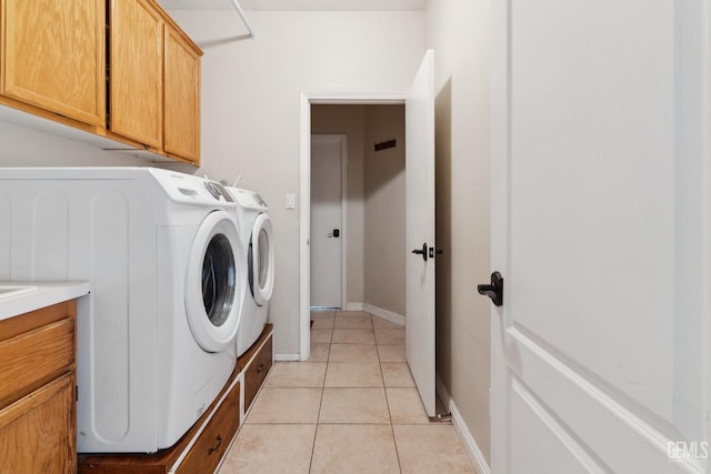 washroom featuring cabinet space, light tile patterned floors, baseboards, and washer and dryer