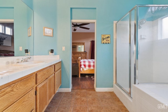 ensuite bathroom with tile patterned flooring, vanity, a ceiling fan, a stall shower, and ensuite bath