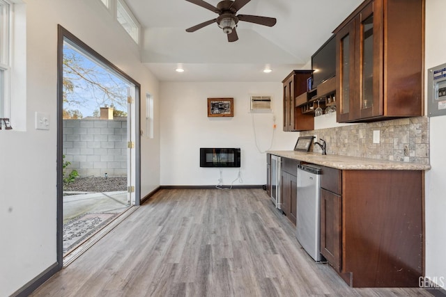 kitchen featuring tasteful backsplash, baseboards, glass insert cabinets, light countertops, and light wood-type flooring