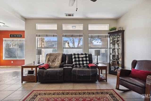 tiled living area with ceiling fan, visible vents, and baseboards