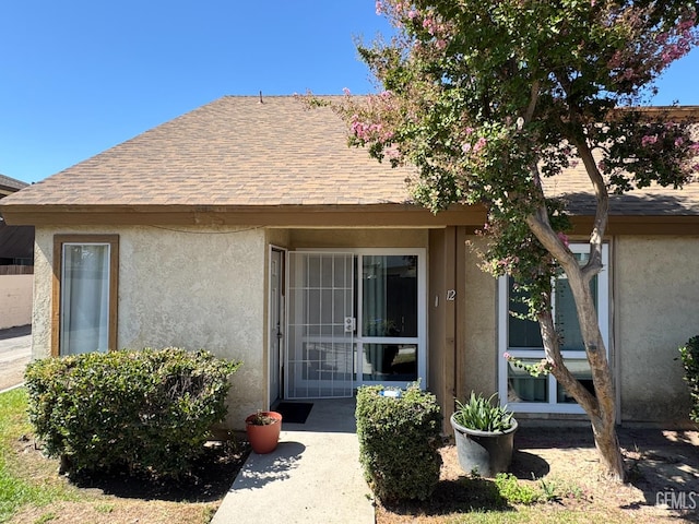 5001 Belle Ter Unit 12, Bakersfield, CA 93309 - view of exterior entry featuring stucco siding and roof with shingles