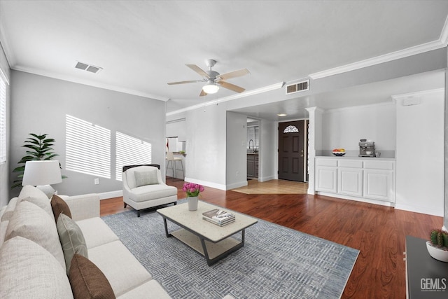 living room with ornate columns, ceiling fan, wood-type flooring, and ornamental molding