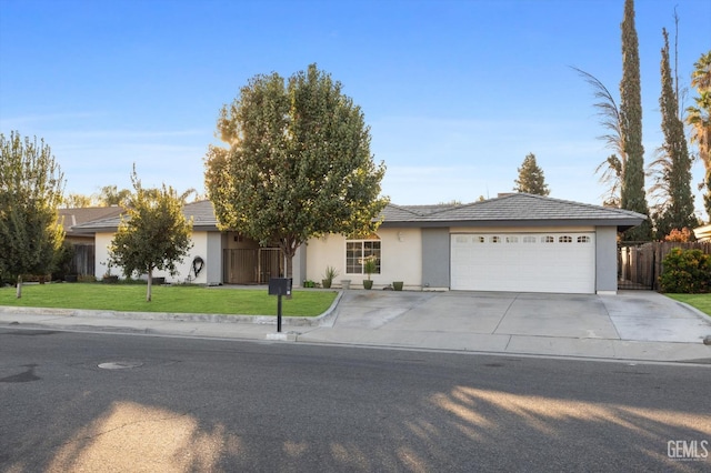 ranch-style house featuring a garage and a front lawn