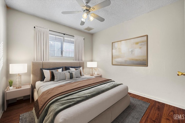 bedroom featuring ceiling fan, dark wood-type flooring, and a textured ceiling