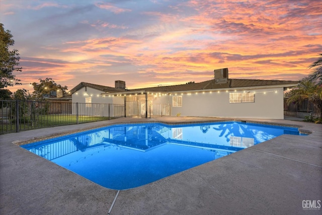 pool at dusk featuring a patio area