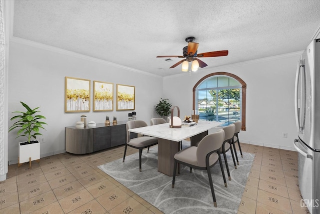 tiled dining room featuring a textured ceiling, ceiling fan, and ornamental molding