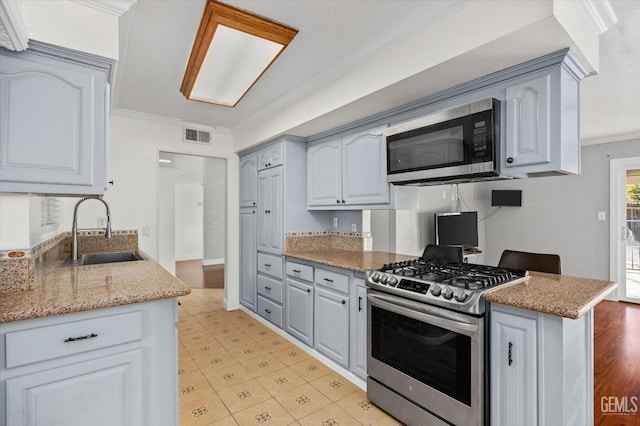 kitchen with crown molding, sink, light stone countertops, and appliances with stainless steel finishes