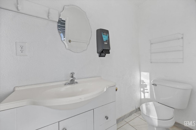 bathroom with tile patterned flooring, vanity, and toilet