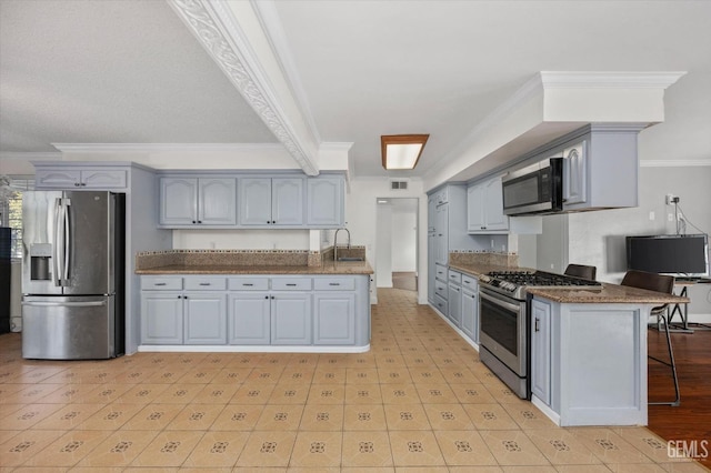 kitchen with sink, ornamental molding, stainless steel appliances, and a breakfast bar area