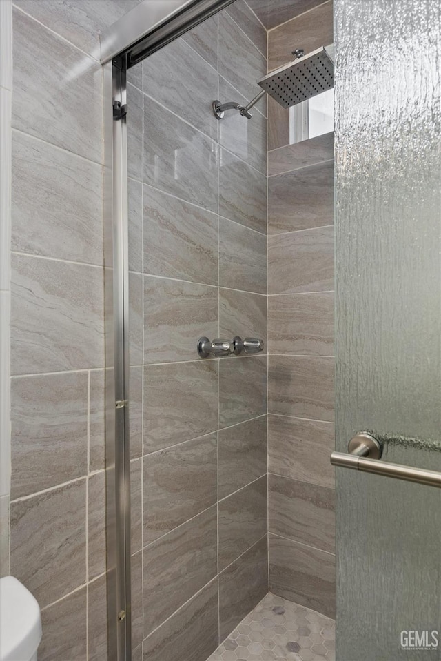 bathroom with toilet and an enclosed shower