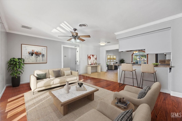 living room featuring crown molding, light hardwood / wood-style flooring, and ceiling fan