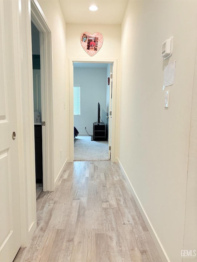 hallway with light hardwood / wood-style floors