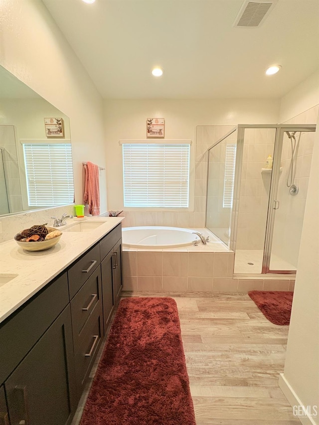 bathroom featuring separate shower and tub, vanity, and wood-type flooring