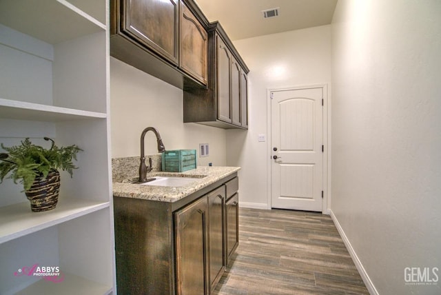 washroom featuring dark wood finished floors, hookup for a washing machine, cabinet space, and baseboards