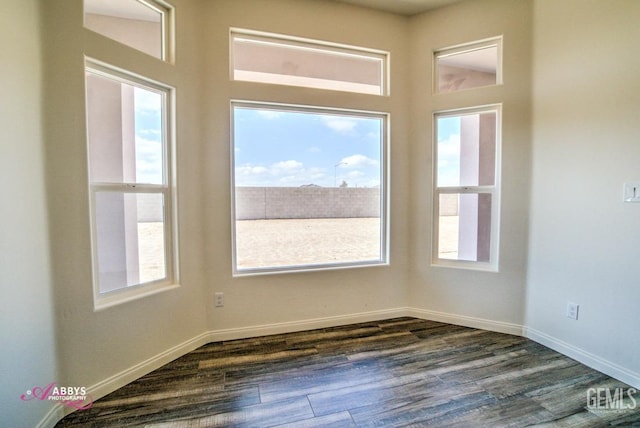 empty room featuring dark wood-style flooring and baseboards