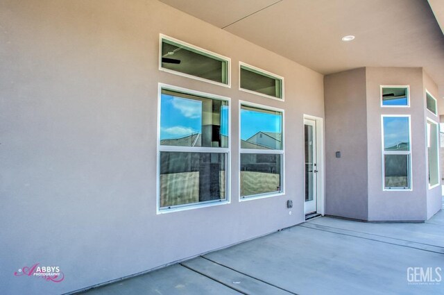 entrance to property with stucco siding and a patio area