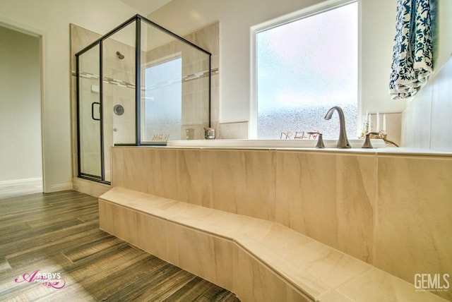 full bathroom with wood finished floors, a stall shower, and baseboards