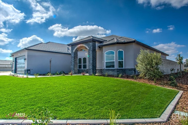 view of front of home featuring a front yard, stucco siding, stone siding, and an attached garage