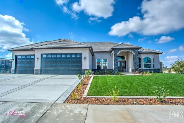 view of front facade featuring a garage, stone siding, driveway, a front lawn, and stucco siding