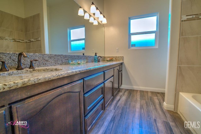bathroom with wood finished floors, a bathtub, double vanity, baseboards, and a shower