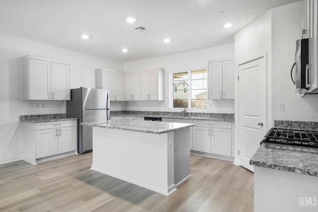5111 Beaverhead Ave, Bakersfield, CA 93306 - kitchen with stainless steel appliances, light wood finished floors, light stone countertops, a kitchen island, and recessed lighting