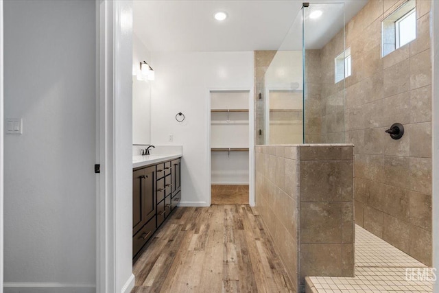 bathroom with vanity, hardwood / wood-style floors, and a tile shower