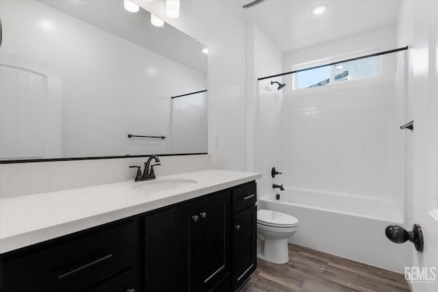 full bathroom featuring vanity, hardwood / wood-style flooring, toilet, and tiled shower / bath