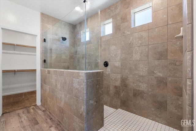 bathroom featuring hardwood / wood-style flooring and a tile shower